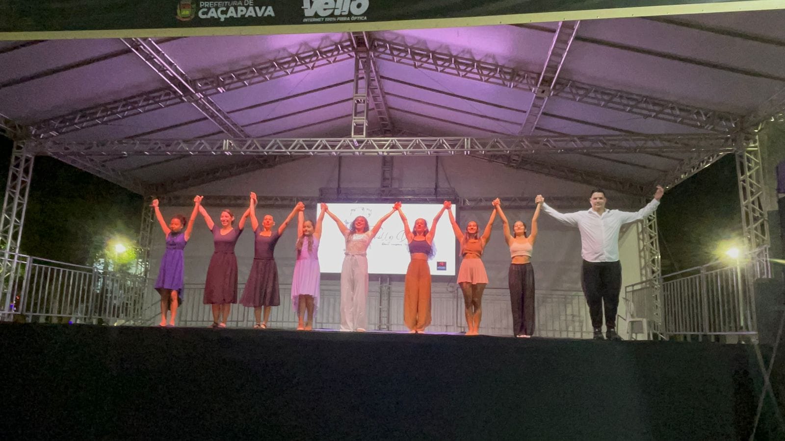 Grupo de alunas de mãos dadas no palco
